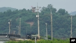 A North Korean military guard post, top, and South Korean military vehicle, bottom, are seen from Paju, South Korea, near the border with North Korea, July 21, 2024.