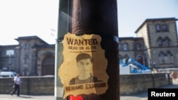 FILE - A wanted sign featuring an image of Daniel Abed Khalife, a former soldier suspected of terrorism offenses, is displayed near Wandsworth prison, from which he escaped, in London, Sept. 7, 2023.