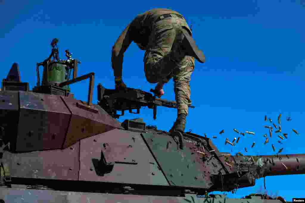 A service member of the 37th Marine Brigade of the Ukrainian Armed Forces removes empty cartridges from a French AMX-10 RC armored fighting vehicle during military drills, in an undisclosed location in Southern Ukraine, April 3, 2024.
