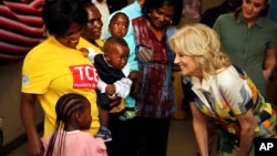 U.S. first lady Jill Biden, right, smiles at children during a visit to a U.S. President's Emergency Plan for AIDS Relief project at an informal settlement near Windhoek, Namibia, Feb. 23, 2023.