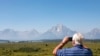 FILE - Steve Carringer of Tennessee takes a photo of the mountains at Jackson Lake Lodge, the site of the Jackson Hole Economic Symposium, in Grand Teton National Park near Moran, Wyo., Aug. 22, 2024. 