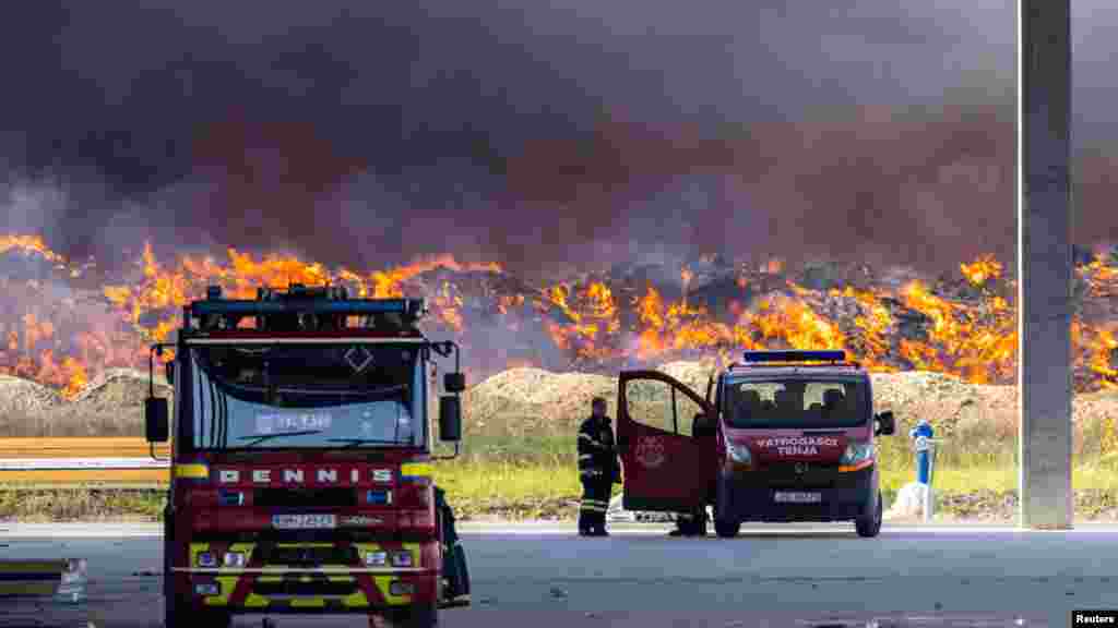 Пожарникар стои во близина на пожарот во фабриката Драва Интернационал во близина на Осиек, Хрватска.