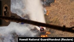 Hawaii Army National Guard CH47 Chinook helicopters perform aerial water bucket drops on the island of Maui to assist with fight of wildfires in Maui, Hawaii, Aug. 9, 2023.