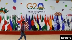 A man walks near flags ahead of G20 Summit in New Delhi, Sept. 8, 2023. 