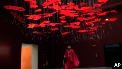A man wearing traditional Masai clothes walks under an installation at the Biennale International Architecture exhibition in Venice, Italy, May 17, 2023. The 18th edition of the Biennale International Architecture exhibition will open to the public from May 20 to Nov. 26, 2023.