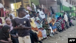 FILE - People from states of Khartoum and al-Jazira, displaced by the ongoing conflict in Sudan between the army and paramilitaries, wait to receive aid from a charity organization in Gedaref on December 30, 2023.