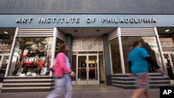 FILE - People walk past the Art Institute of Philadelphia operated by the Education Management Corporation on Nov. 16, 2015, in Philadelphia.