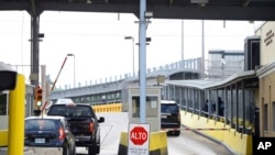 FILE - Motorists pay a toll at Gateway International Bridge, March 6, 2023, in Brownsville, Texas, to cross into Matamoros, Mexico.