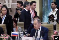 Menteri Luar Negeri AS Antony Blinken, tengah atas, berjalan melewati Menteri Luar Negeri Rusia Sergey Lavrov selama pertemuan para menteri luar negeri G20 di New Delhi Kamis, 2 Maret 2023. (Foto: Olivier Douliery via AP)