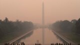 With the Washington Monument in the background and a thick layer of smoke, Marine Corps honor color guard rehearse, June 8, 2023, in Washington.