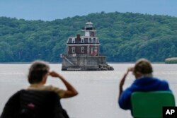 People look at the Hudson-Athens Lighthouse, June 12, 2024, in Hudson, New York.