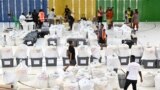 Petugas pemilu menyiapkan kotak suara sebelum memulai penghitungan suara di Honiara, ibu kota Solomon, 18 April 2024. (Saeed KHAN/AFP)
