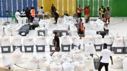 Petugas pemilu menyiapkan kotak suara sebelum memulai penghitungan suara di Honiara, ibu kota Solomon, 18 April 2024. (Saeed KHAN / AFP)