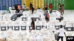 Petugas pemilu menyiapkan kotak suara sebelum memulai penghitungan suara di Honiara, ibu kota Solomon, 18 April 2024. (Saeed KHAN / AFP)