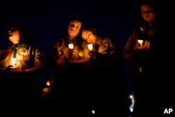 La gente se reúne en una vigilia en Lisbon Falls, Maine, por las víctimas de los tiroteos masivos de la semana, el sábado 28 de octubre de 2023. (Foto AP/Matt Rourke)