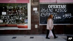 A woman walks by a meat market in Buenos Aires, Argentina, May 11, 2023. According to a recent World Bank Food Security report, Argentina has seen a 107% annual inflation rate in food prices.