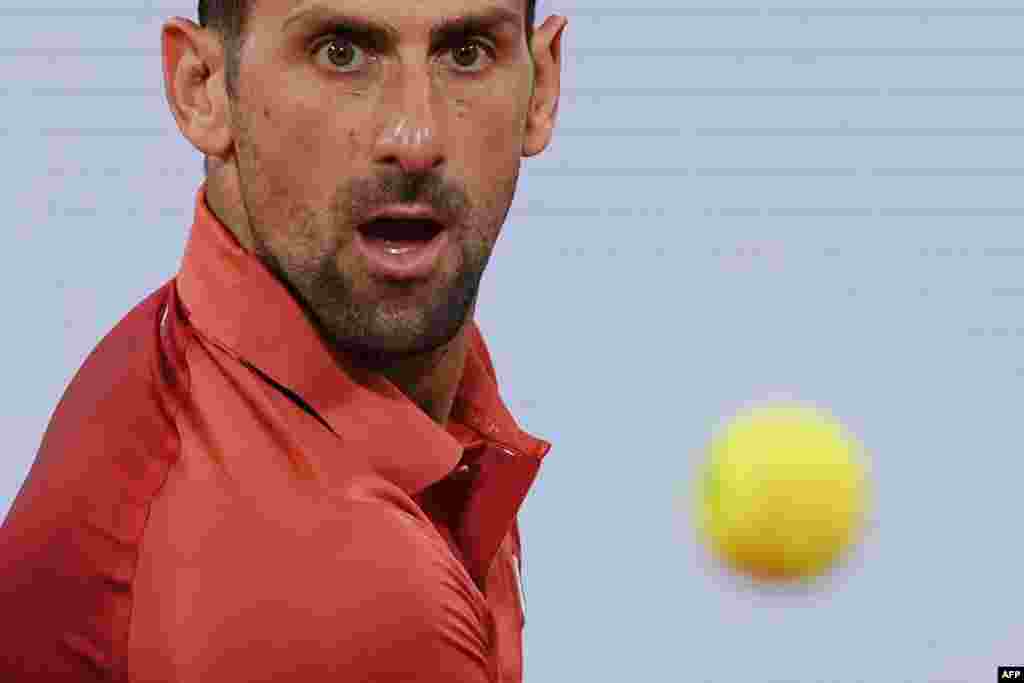 Serbia's Novak Djokovic eyes the ball as he plays in a men's singles match during the French Open tennis tournament at the Roland Garros Complex in Paris.
