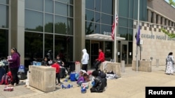 Inigrantes, sin un lugar donde quedarse al llegar a la ciudad, buscan refugio seguro en la estación del Distrito 12 del Departamento de Policía Local en Chicago, EEUU, el 17 de mayo de 2023.