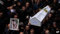 Mourners from the Druze minority carry the coffins of some of the 12 children and teens killed in a rocket strike at a soccer field during their funeral, in the village of Majdal Shams, in the Israeli-annexed Golan Heights, July 28, 2024. 