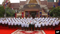 FILE - Cambodia's King Norodom Sihamoni, front center, poses with the nation's lawmakers during a photo session in front of the National Assembly in Phnom Penh, Cambodia, Wednesday, Sept. 5, 2018.