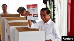 FILE: Presiden Jokowi saat berada di balik bilik suara Pemilu di salah satu TPS di Jakarta, 17 April 2019. (REUTERS/Edgar Su)
