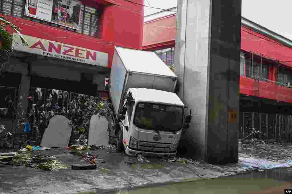 A truck is seen stuck in a fence in the aftermath of Typhoon Gaemi in Manila, Philippines, July 25, 2024. 