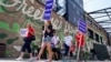 Supporters of former president Donald Trump walk near the Fiserv Forum on Aug. 22, 2023, the day before the Republican presidential debate in Milwaukee, Wisconsin. Though Trump is skipping the debate, he still has a presence at the event.