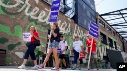 Supporters of former president Donald Trump walk near the Fiserv Forum on Aug. 22, 2023, the day before the Republican presidential debate in Milwaukee, Wisconsin. Though Trump is skipping the debate, he still has a presence at the event.