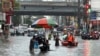 ဖိလစ်ပိုင်နိုင်ငံ မနီလာမြို့တော်မှာ ရေကြီးနေတဲ့လမ်းတွေကြား သွားလာနေကြရသူများ (ဇူလိုင် ၂၄၊ ၂၀၂၄)