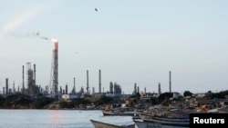 Fishing boats are moored near Paraguana Refining Center, the largest refinery of Venezuelan state energy company PDVSA, on Oct. 2, 2021, following a crude spill in September from a connecting pipeline, in Punta Cardon, Venezuela.