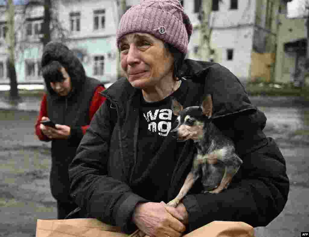 A civilian evacuated from Bakhmut cries while carrying her shivering Chihuahua, Margot, after stepping out of a Ukrainian army armored personnel carrier in Chasiv Yar, amid the Russian invasion of Ukraine.