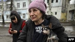 A civilian evacuated from Bakhmut cries while carrying her shivering Chihuahua, Margot, after stepping out of a Ukrainian army armored personnel carrier in Chasiv Yar, amid the Russian invasion of Ukraine.