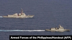 The U.S. Navy's USS Ralph Johnson guided missile destroyer (L) and the Philippine Navy frigate BRP Jose Rizal sail through waters west of Palawan in the South China Sea, Sept. 4, 2023.