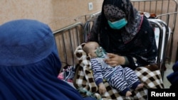 عکس آرشیف، یک زن افغان فرزندش را برای تداوی بیماری تنفسی به بیمارستانی در کابل آورده است