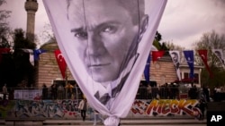 A worker removes a giant banner with the image of Mustafa Kemal Ataturk, founder of modern Turkey, at the end of a rally by Istanbul Mayor and main opposition CHP party member Ekrem Imamoglu, in Istanbul, Turkey, April 26, 2023. 