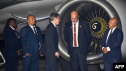 Papua New Guinea's Deputy Prime minister John Rosso (2R) greets US Secretary of State Antony Blinken (C) upon his arrival at Port Moresby International Airport, New Guinea, May 21, 2023.