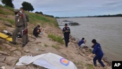 资料照片：2018年12月27日，泰国救援人员在泰国曼谷东北部的呵叻拍侬省湄公河岸边覆盖一具尸体。警方于2019年1月22日表示，DNA测试显示，在泰国湄公河岸边发现的两具尸体是反政府活动人士的尸体，怀疑是政治杀戮。（美联社照片）