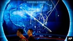 资料照片：2017年9月12日，在北京举行的中国互联网安全大会上，与会者走过显示中国最近受到网络攻击的电子显示屏。（美联社照片）
