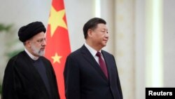 Iranian President Ebrahim Raisi stands next to Chinese President Xi Jinping during a welcoming ceremony in Beijing, China, Feb. 14, 2023. (West Asia News Agency/Handout via Reuters)