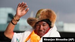 FILE - In this May 20, 2018 photo, Nepalese Sherpa guide, Kami Rita waves as he arrives in Kathmandu, Nepal. Rita regained his title with the most climbs of Mount Everest after scaling the peak for the 27th time on Wednesday. (AP Photo/Niranjan Shrestha,)