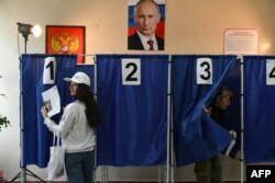 Voters cast ballots in Russia's presidential election at a polling station in Donetsk, Russian-controlled Ukraine, amid the Russia-Ukraine conflict, March 16, 2024.
