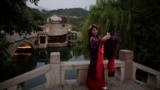 一名穿着传统服装的妇女在北京热门旅游景点古北水镇的古村落里自拍。中国拟扩大免签吸引更多外籍观光客。(美联社：2020年6月9日)