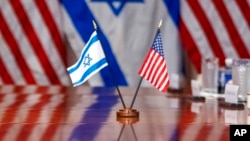 Israeli and U.S. flags are reflected on a conference table where Defense Secretary Lloyd Austin met with Israeli Defense Minister Yoav Gallant, at the Pentagon, March 26, 2024, in Washington.