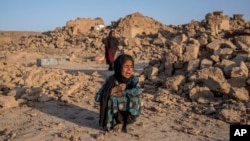 An Afghan girl cries in front of her house that was destroyed by the earthquake in Zindajan district in the Herat province of western Afghanistan, Oct. 11, 2023. 