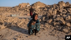 An Afghan girl cries in front of her house, which was destroyed by the earthquake in Zindajan district in the Herat province of western Afghanistan, Oct. 11, 2023. 