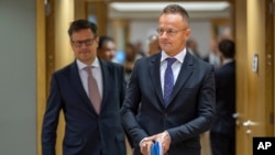 Hungary's Foreign Minister Peter Szijjarto, right, arrives for a meeting of EU foreign ministers at the European Council building in Brussels, July 22, 2024. 