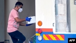 A health worker carries a box of samples to a medical research mobile testing facility in Kozhikode, Kerala state, India, Sept. 15, 2023. India has curbed public gatherings and shut some schools in the state after two people died of the Nipah virus.