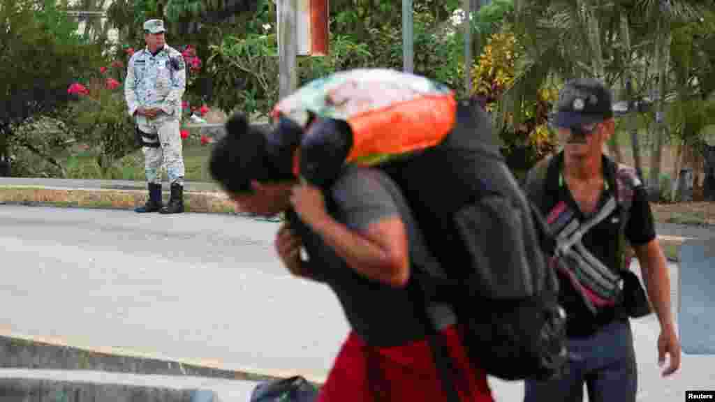 Un miembro de la Guardia Nacional vigila a los migrantes. 