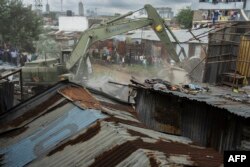 Rumah-rumah di tepi sungai di daerah kumuh Mukuru, Nairobi, dihancurkan dengan menggunakan alat berat (buldozer), 8 Mei 2024. Badan keamanan Kenya diperintahkan untuk mengevakuasi semua orang yang tinggal di daerah rawan banjir dan tepi sungai. (SIMON MAINA / AFP)