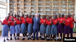 King Charles III poses with cheering students during his visit to Eastlands Library in Nairobi, Kenya, with Queen Camilla, where the king joined young people taking part in a Prince’s Trust International Enterprise Challenge on Oct. 31, 2023.
